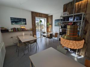 a living room with tables and chairs and a fireplace at Nexø Modern Hostel. Private Rooms in Neksø
