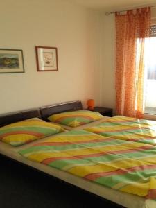 a bed with a colorful comforter in a bedroom at Apartments Da - Dent in Sveti Ivan Zelina