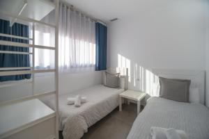 ein kleines Schlafzimmer mit 2 Betten und einem Fenster in der Unterkunft Apartamento El Carmen by Be Alicante in Alicante