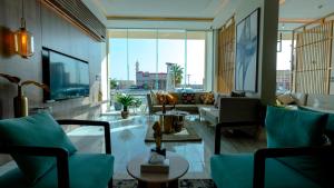 una sala de estar con muebles azules y una gran ventana. en فندق ارجان بارك Arjan Park Hotel, en Wadi Al Dawasir