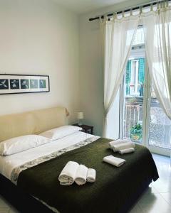 una camera da letto con un letto con due asciugamani e una finestra di Bed & Breakfast Plebiscito Home a Napoli