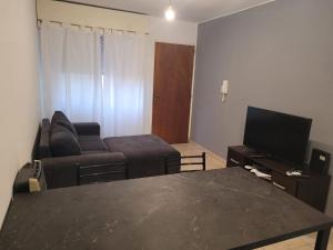 a living room with a couch and a tv at Departamento Puerta del Rio in Villa María