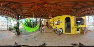 a large room with a yellow building with a wooden ceiling at Namaste Hospedagem in Natal