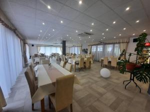a dining room with tables and chairs in a building at Klágya Vendégház in Dávod