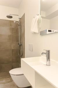 a white bathroom with a toilet and a sink at Beautiful Apartments on Strøget in Copenhagen City Center in Copenhagen +51 photos