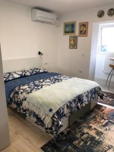 een slaapkamer met een bed met een blauwe en witte deken bij Brand New Downtown Studio in Boekarest