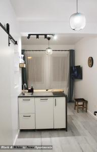 a kitchen with a sink and a counter top at Black & White - News Apartment in Bucharest