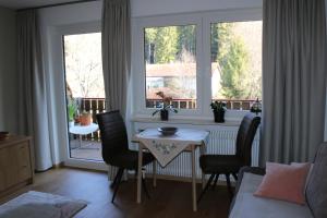 ein Wohnzimmer mit einem Tisch, Stühlen und einem Fenster in der Unterkunft Appartement Kopp am Kirnberg See in Unterbränd