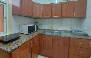 a kitchen with a sink and a microwave at Nice studio for stay .. in Al Ain