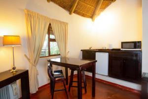 a dining room with a table and a microwave at Warthogs Bush Lodge in Magaliesburg