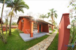 ein kleines rotes Haus mit Veranda und Tisch in der Unterkunft Cabanas Termas Hotel in Gravatal