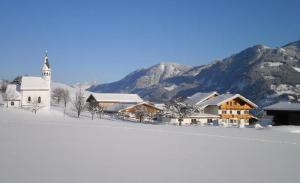 a church and a snow covered field with a church at Veitnhof Vomperberg in Vomp