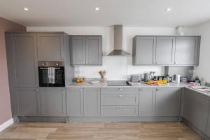 a kitchen with gray cabinets and white counters at BOURNECOAST: STYLISH FLAT WITH BALCONY - SEA VIEWS - PARKING - WIFI - FM8407 in Southbourne