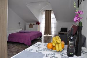 um quarto com uma garrafa de vinho e uma taça de fruta em Apartment Danijela em Okuklje