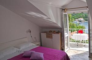 um quarto com uma cama e uma varanda com uma mesa em Apartment Danijela em Okuklje