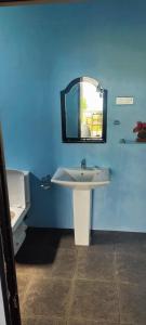a blue bathroom with a sink and a mirror at Jungle Beach Restaurant And Hotel-JBR in Galle +33 photos