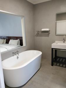 a white bathroom with a tub and a sink at Lake Kariba Inns in Siavonga