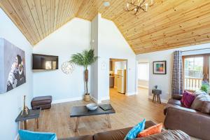 a living room with a couch and a wooden ceiling at Kestrel Lodge 7 with Hot Tub in Newton Stewart