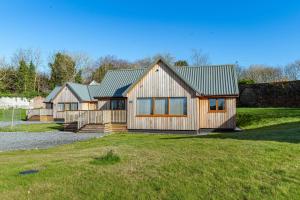 a large wooden house with a large yard at Kestrel Lodge 7 with Hot Tub in Newton Stewart