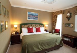 a bedroom with a large bed with red pillows at Imperial Hotel in Great Yarmouth