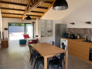 eine Küche und ein Esszimmer mit einem Tisch und Stühlen in der Unterkunft villa Pwintosel 2 in Saint-Leu