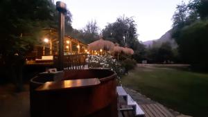 - un restaurant avec un bain à remous dans une cour le soir dans l'établissement Cabañas Parque Almendro, à San José de Maipo