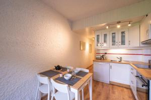 - une cuisine avec une table en bois et des placards blancs dans l'établissement Beautiful Studio With Garden Quiet Area, à Saint-Gervais-les-Bains