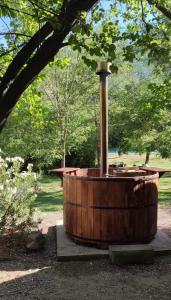 eine hölzerne Badewanne mit einem Brunnen in einem Park in der Unterkunft Cabañas Parque Almendro in San José de Maipo