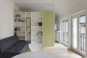 een woonkamer met een zwarte bank en een boekenplank bij Luce Suit - your windows on the city Milano in Milaan