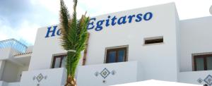 a white building with a blue sign on it at Hotel Egitarso Sul Mare in San Vito lo Capo
