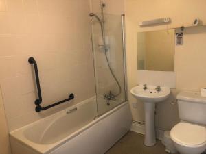 a bathroom with a shower and a toilet and a sink at Wayfarer Inn in Instow