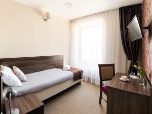 1 dormitorio con cama, escritorio y ventana en Hotel Dąbrowski, en Oświęcim