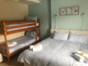 a bedroom with two bunk beds with towels on them at Wayfarer Inn in Instow