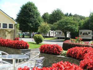a table and chairs in a garden with red flowers at Flemings White Bridge Self-Catering Mobile Home Hire in Killarney