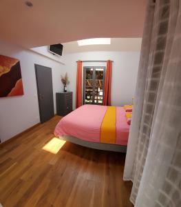 1 dormitorio con 1 cama con una manta colorida en Chambres à la Campagne en Moirans