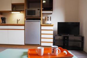 eine Küche mit einer Mikrowelle und einem Tisch mit Tassen in der Unterkunft Apartment Historical City Center in Annecy