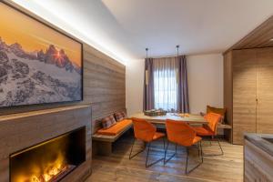 a living room with a fireplace and a table and chairs at Cima Dodici B&B - Apartments in Sesto