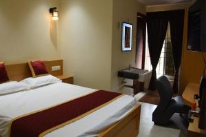 Habitación de hotel con cama y lavabo en Masa mahal and lodge, en Sivaganga