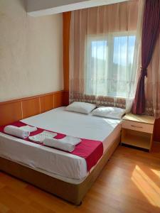 a bedroom with a large bed with a window at Mustafa Hotel in Pamukkale