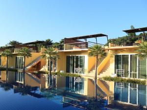 un edificio con palmeras junto a una piscina en BANGKOK.GRAND.RESORT en Bang Bo