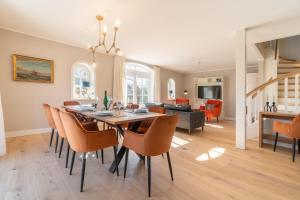 comedor y sala de estar con mesa y sillas en Haus Hilde en Oevenum