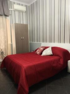 a bedroom with a large red bed with two pillows at Tarsia Suite in Naples
