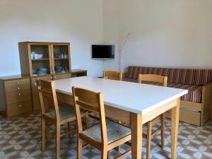 a living room with a table and chairs and a couch at Mirafiori Apartment in Grado