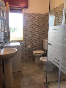 a bathroom with a sink and a toilet and a window at Mirafiori Apartment in Grado