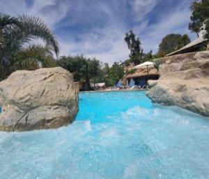 een zwembad met blauw water en grote rotsen bij Studio Alba Beach in El Campello