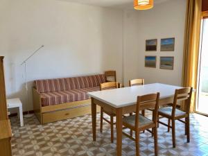 a living room with a table and chairs and a couch at Mirafiori Apartment in Grado