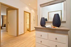 ein Zimmer mit einer Kommode mit Vasen darauf in der Unterkunft Seehof Bansin, App. 21 in Bansin