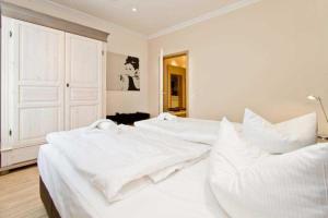 ein weißes Schlafzimmer mit 2 Betten und weißer Bettwäsche in der Unterkunft Seehof Bansin, App. 21 in Bansin + 34 Fotos