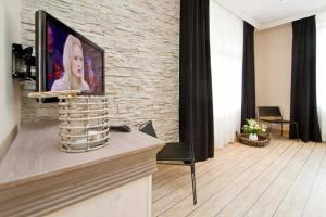 ein Wohnzimmer mit einem Flachbild-TV an einer Backsteinwand in der Unterkunft Seehof Bansin, App. 21 in Bansin