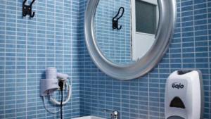 Un baño con azulejos azules, espejo y lavabo. en ΑΡΑΪΔΟΥ΄-ARAIDOY, en Ioannina